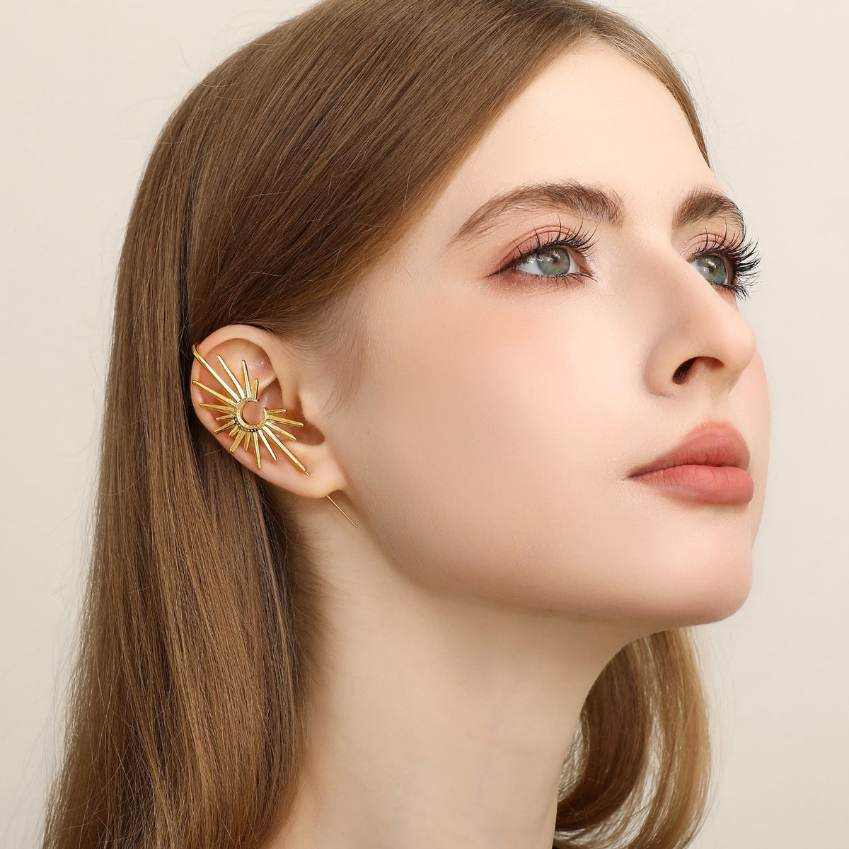 A woman wearing the gold Sunray statement earring
