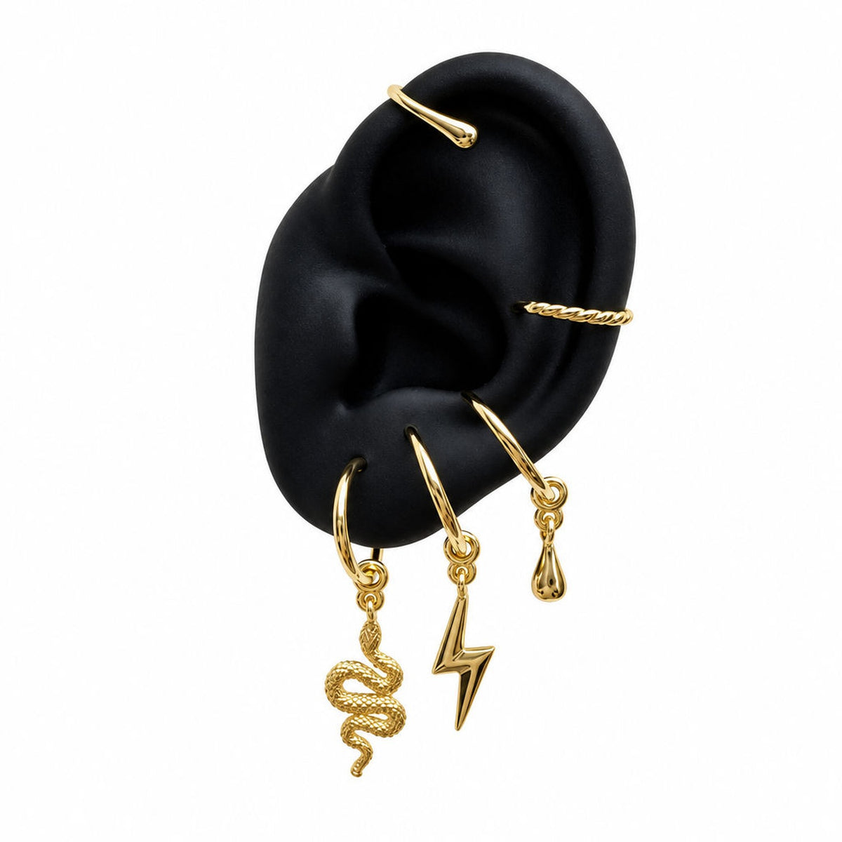 Gold Charm Cuff with serpent, lightning bolt and raindrop charms on display ear