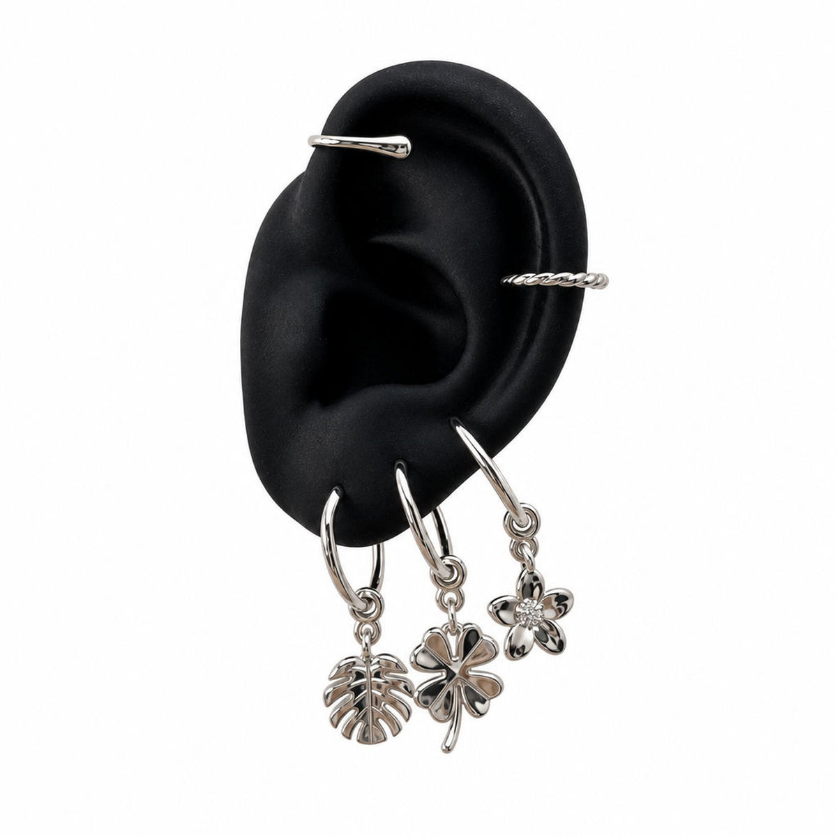 Silver Charm Cuff with botanical charms on display ear