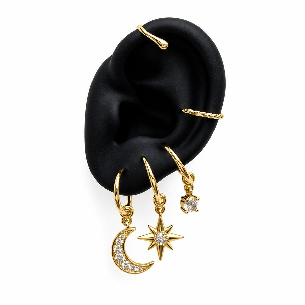 Gold Charm Cuff with moon, star and round sparkle charms on display ear